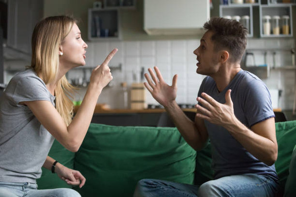 Angry millennial couple arguing shouting blaming each other of problems stock photo